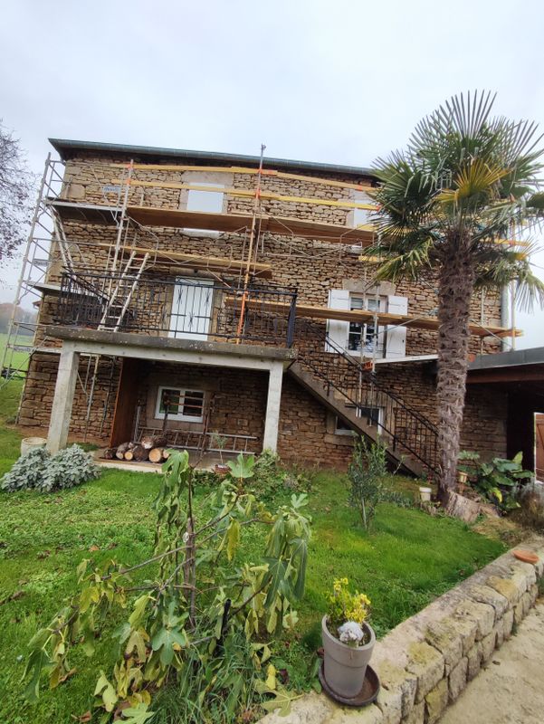 Grande maison en pierre en cours de rénovation avec échafaudage